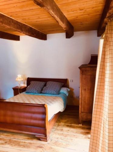 une chambre avec un lit et un plafond en bois dans l'établissement La maisonnette, à Le Nayrac