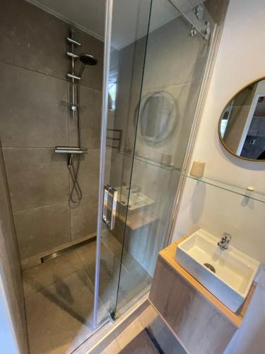 La salle de bains est pourvue d'une douche et d'un lavabo. dans l'établissement Bed & Bike Gasthuus Texel, à Den Burg