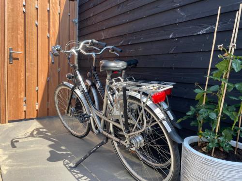 a bike parked next to a building next to a door at Bed & Bike Gasthuus Texel in Den Burg