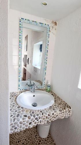 a bathroom with a sink and a mirror at Casa Pescador Beach House in Struisbaai