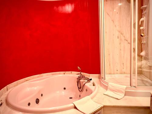a red bathroom with a tub and a shower at Marina de Campios in Comillas
