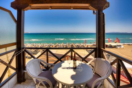 uma mesa com cadeiras e vista para a praia em Troulis Seaside em Amoudara Herakliou