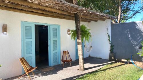a house with a blue door and a palm tree at Villa Parazinho in Paracuru