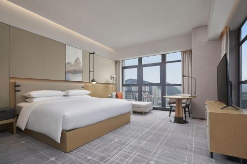 貴陽市にあるFour Points by Sheraton Guiyang, Huaxiのベッドとテレビが備わるホテルルームです。