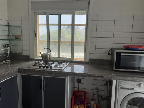 y cocina con fogones y microondas. en Magnifique villa avec piscine, en Kenitra