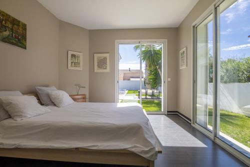 a bedroom with a large bed and a large window at Envie de Vivre in Agde
