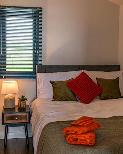 a bedroom with a bed with a red blanket on it at Lough Beg Glamping in New Ferry