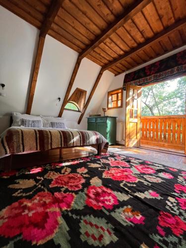 a bedroom with a bed and a large rug at The Village Pension in Breb