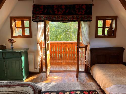 Dormitorio con ventana, cama y puerta en The Village Pension en Breb
