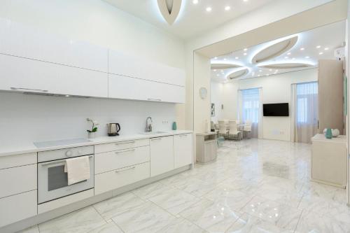 a white kitchen with white cabinets and a tv at Luxurious Central Apartment next to the Danube River in Budapest