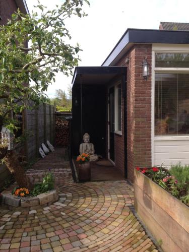 una persona sentada en la puerta de una casa en Studio Lakeside Spiegelplas en Nederhorst den Berg