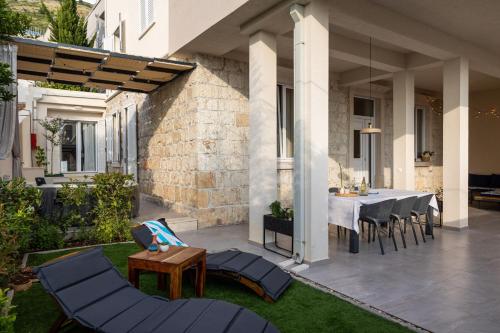 un patio con mesa de comedor y sillas en Apartments aMare en Dubrovnik