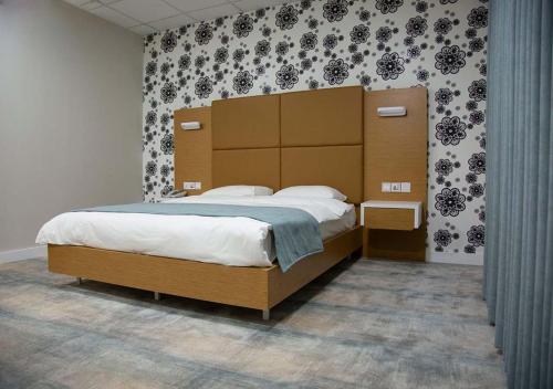 a bedroom with a large bed with a large headboard at Rawaz Hotel & Motel in As Sulaymānīyah