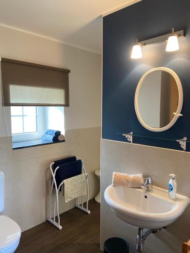 een badkamer met een wastafel en een spiegel bij En Vert & En Pause in Thimister