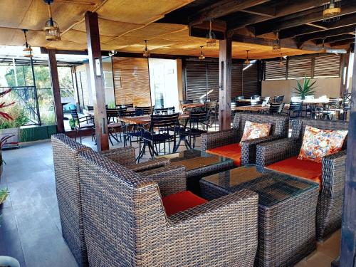 un restaurant avec des tables, des tables et des chaises en osier dans l'établissement FLY INN Madagascar HOTEL - Navette GRATUITE H24 - à 300m de l'Aéroport International Ivato-Antananarivo, à Ivato