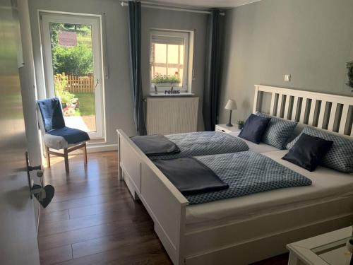 1 dormitorio con 1 cama, 1 silla y 1 ventana en Ferienwohnung Mohnbrise, en Germerode