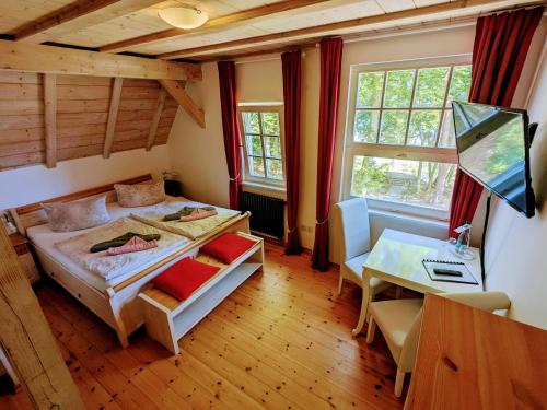 a bedroom with a bed and a desk and window at Strandhotel Lindequist in Ostseebad Sellin