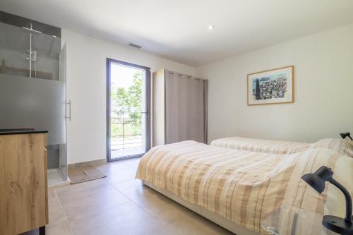 Un dormitorio con una cama y una ventana grande. en Villa Orsan, en Orsan
