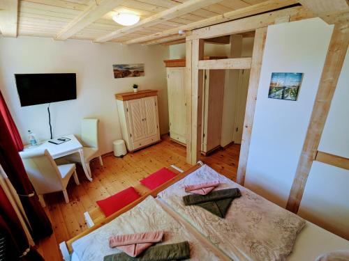 een kamer met een bed, een bureau en een televisie bij Strandhotel Lindequist in Ostseebad Sellin