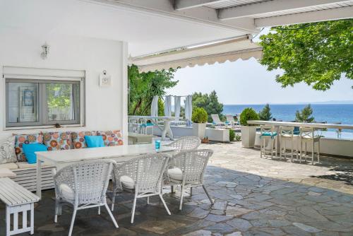 a patio with a table and chairs and the ocean at SEA VIEW Ranch By the Sea in Vatopedi