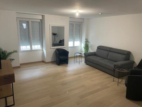 een woonkamer met een bank en een tafel bij Appartement centre ville - Sablé sur Sarthe in Sablé-sur-Sarthe