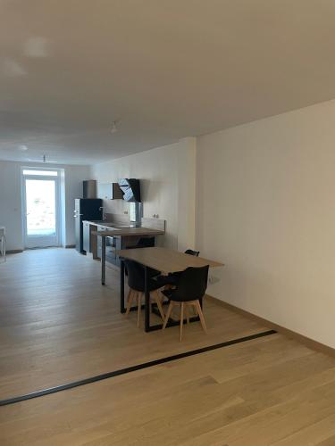 une pièce avec une table et des chaises et une cuisine dans l'établissement Appartement centre ville - Sablé sur Sarthe, à Sablé-sur-Sarthe