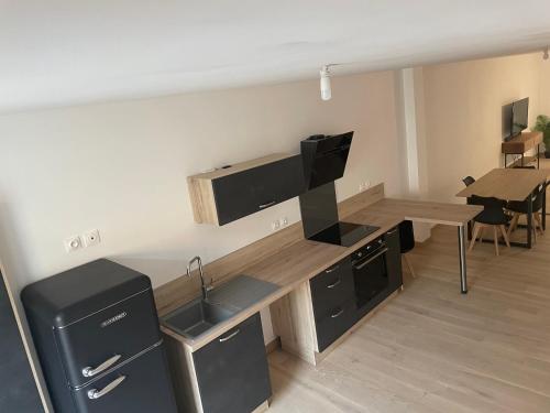 een keuken met een bureau, een televisie en een wastafel bij Appartement centre ville - Sablé sur Sarthe in Sablé-sur-Sarthe