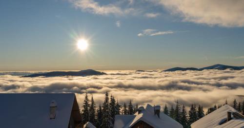 a view of the sun rising above a layer of clouds at Pensiunea Pusu in Ranca