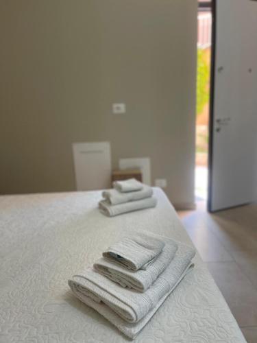 3 toallas sentadas encima de una cama en B&B Licia Home, en Voghera