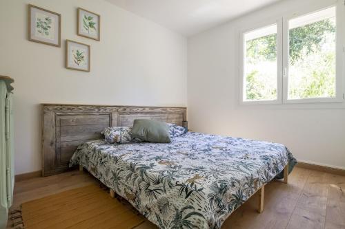 une chambre avec un lit et deux fenêtres dans l'établissement Le Dali, à Piolenc