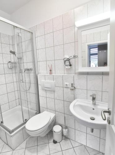 a white bathroom with a toilet and a sink at Ferienwohnung La Finesse in Bad Salzungen