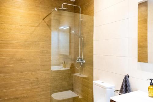 y baño con ducha, aseo y lavamanos. en 4 Bed Residential Palm Beach Fuengirola C1 en Fuengirola