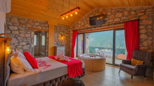 a bedroom with a bed and a tub in a room at VİLLA VAVEYLA in Oludeniz