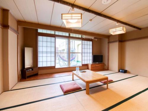 a large room with a table and a tv at Hotel Mifuji Yamanakako in Yamanakako