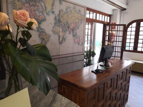 a desk with a computer on it with a map on the wall at Hotel Ramis fundado en 1969 in Ondara
