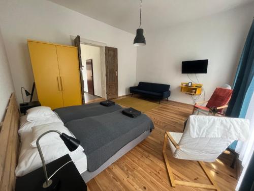 - une chambre avec un lit, un canapé et une chaise dans l'établissement Várkerület 6 Apartman, à Sárvár