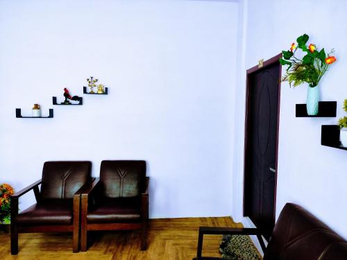 uma sala de estar com uma cadeira e um vaso de flores em Chawngthu Lodge em Āīzawl