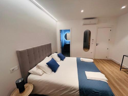 a bedroom with a large bed with blue and white pillows at Apartamentos TriBeca Centro II in Albacete