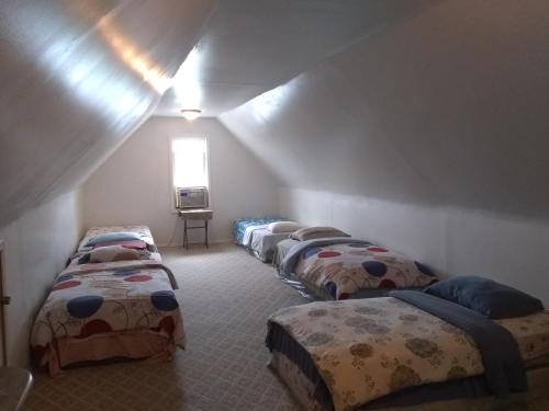 Cette chambre mansardée comprend une rangée de lits. dans l'établissement 5430 Happy Home, à Chicago