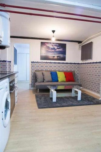 salon z kanapą i kolorowymi poduszkami w obiekcie A Unos Pasos Para Gran Via Madrid Xxl w Madrycie