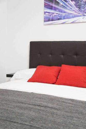 una camera da letto con un letto con cuscini rossi di A Unos Pasos Para Gran Via Madrid Xxl a Madrid