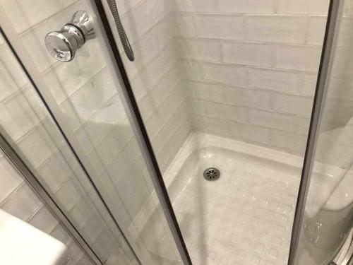 a white shower with a glass door and a shower at Una genial estancia en el barrio las cortes in Madrid