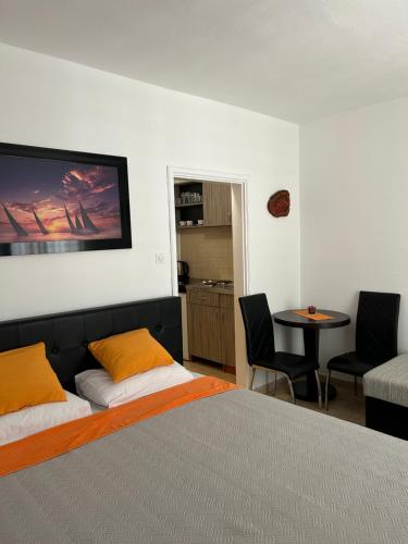 a bedroom with a bed and a table and chairs at Apartmani Kažanegra33 in Pržno