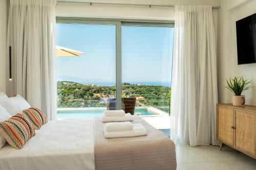 a bedroom with a bed and a large window at Evora Suites in Chania Town