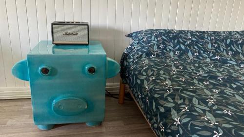 - un lit avec une table bleue et une horloge dans l'établissement Chocolatine, le loft qui donne plus de chocolat! Moulleau, Pyla-sur-Mer, à Pyla-sur-Mer