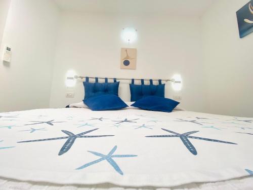 a bedroom with a bed with blue pillows at Casa Leo in Anacapri