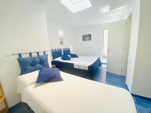 a bedroom with two beds with blue pillows at Casa Leo in Anacapri