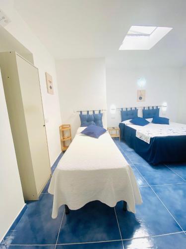 a bedroom with two beds and blue tile floors at Casa Leo in Anacapri