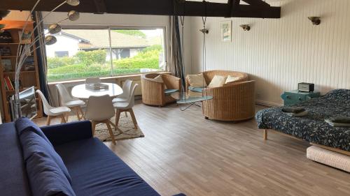 un salon avec un canapé, des chaises et une table dans l'établissement Chocolatine, le loft qui donne plus de chocolat! Moulleau, Pyla-sur-Mer, à Pyla-sur-Mer