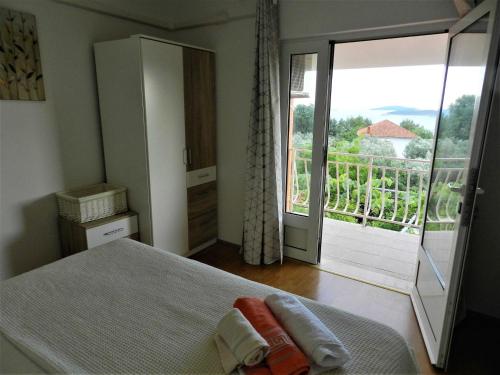 a bedroom with a bed and a view of a balcony at Apartments Lea in Orebić